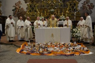Mehrere Priester am Altar, davor Speisekörbe.