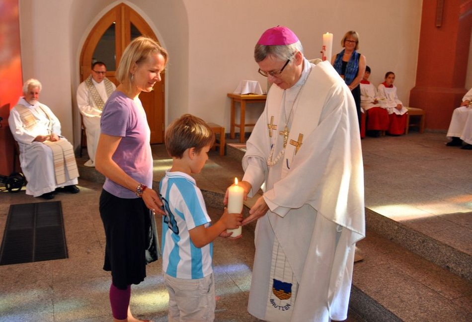 Kinder brachten bei den vier Gottesdiensten zur Gabenbereitung Kerzen zum Altar, hier übergeben an Weihbischof Andrzej Siemieniewski, wobei das jeweilige Tagesthema als Bild auf der Kerze dargestellt wurde.